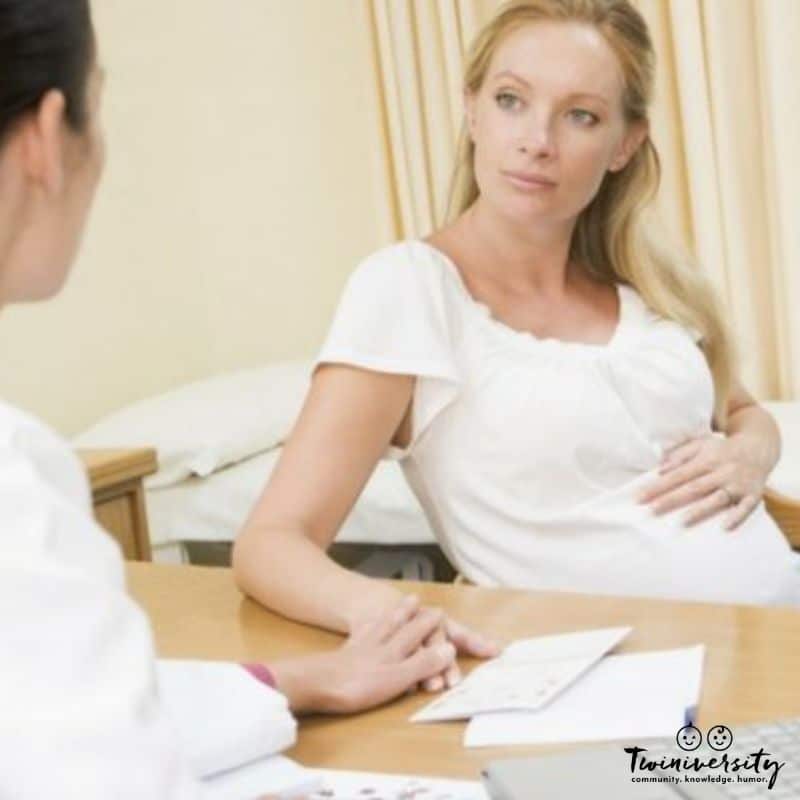 A pregnant woman is in an exam room being consoled by her doctor for a shortened cervix
