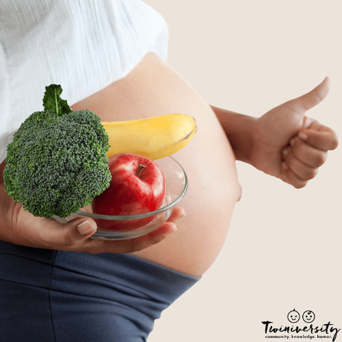 a pregnant woman holds fruit and vegetables to eat when pregnant