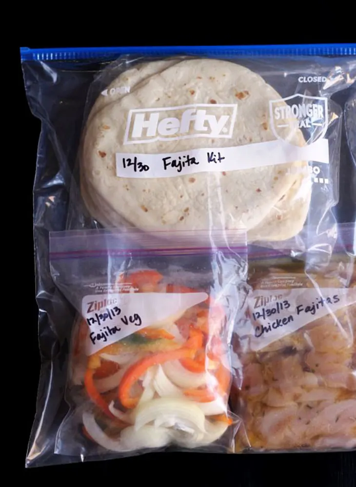Freezer meals: Sliced bell peppers, onions, chicken and tortillas in zip-top bags labels with the date of 12/30/13