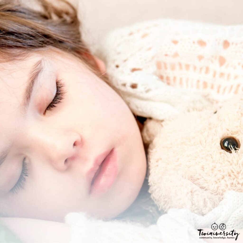 Toddler sleeping with stuffed animal, staying in bed. 