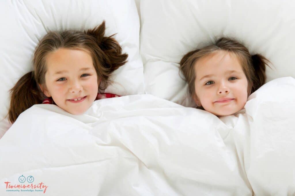 Two sisters sleeping in one bed because it helps them stay in bed at night.