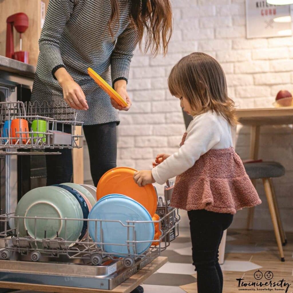 Little girl is helping her mom with dishes, which is an appropriate chore for her age.