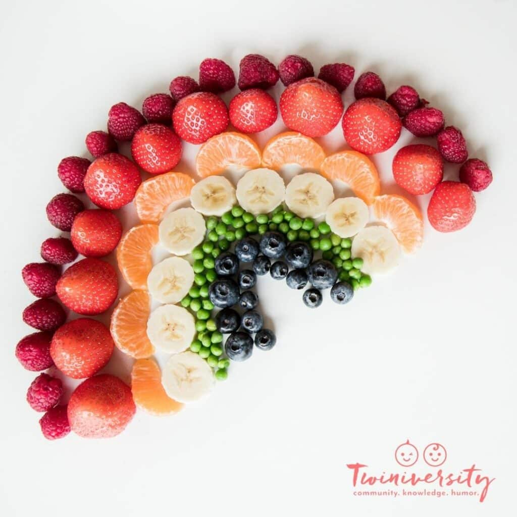 St. Patrick's Day Craft and Snack in the shape of a rainbow. Made with fruits and veggies in colors of the rainbow