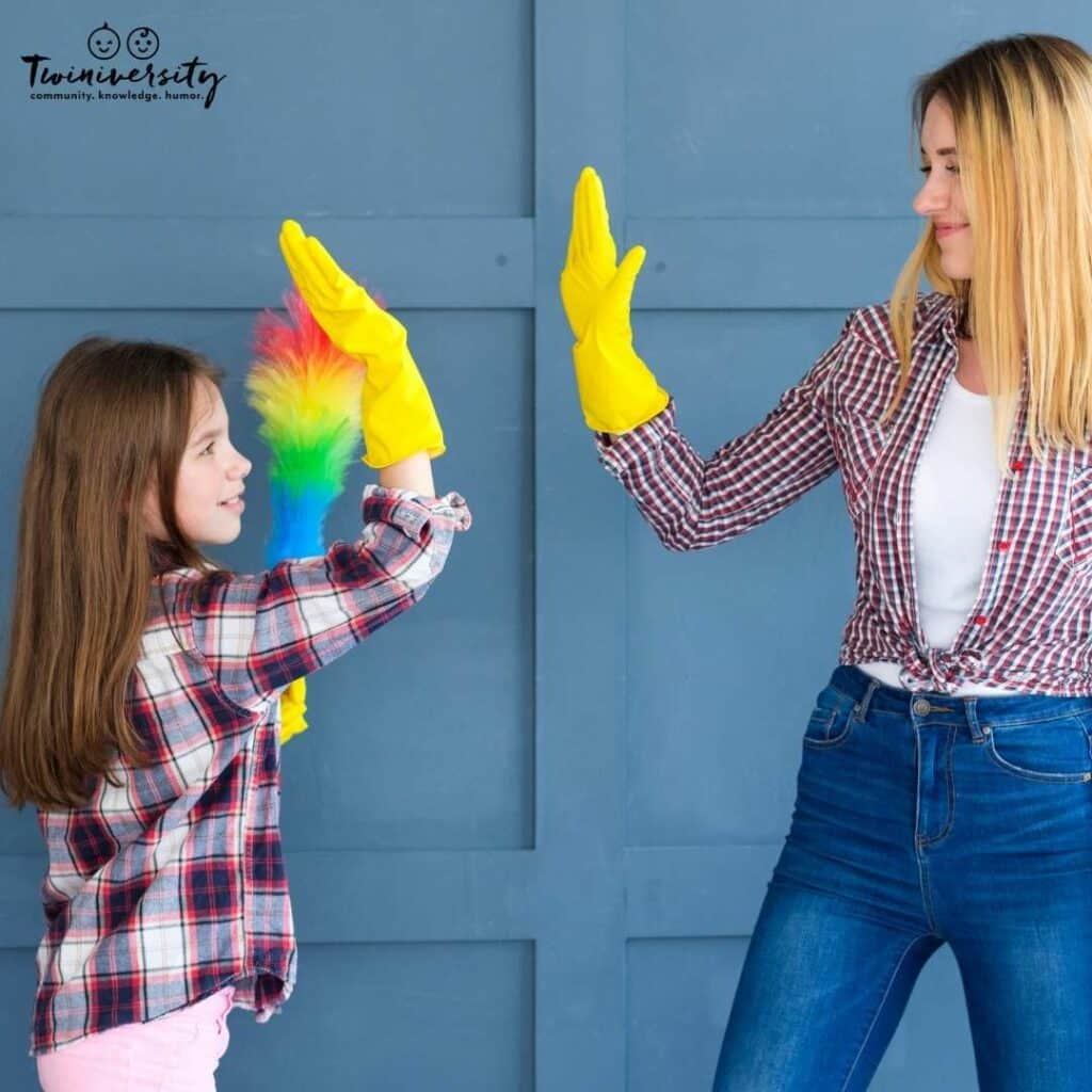 mom and daughter high five while wearing cleaning gloves to celebrate a job well done