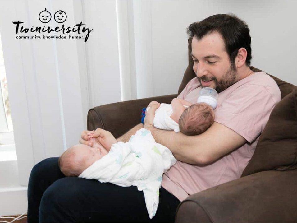 A dad feeding twins in the best bottle-feeding position 