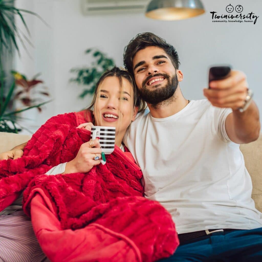 a couple making time for each other on Valentine's day on the couch watching a movie. 