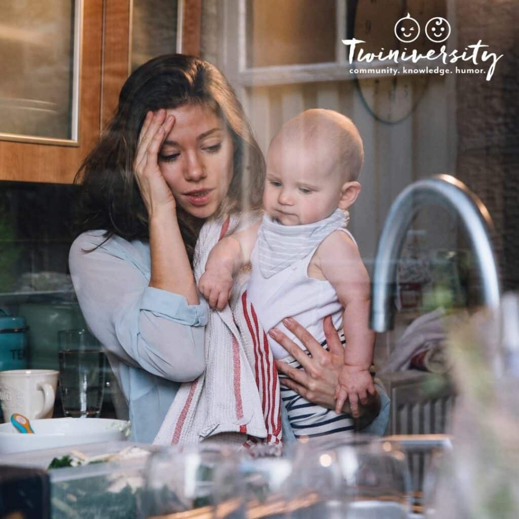 mom is overwhelmed and holding her head and baby, wondering how she will do it all as a single mom.