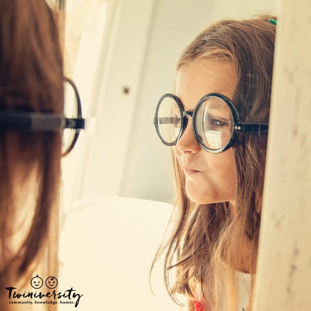 Little girl looking in the mirror trying to build self-confidence