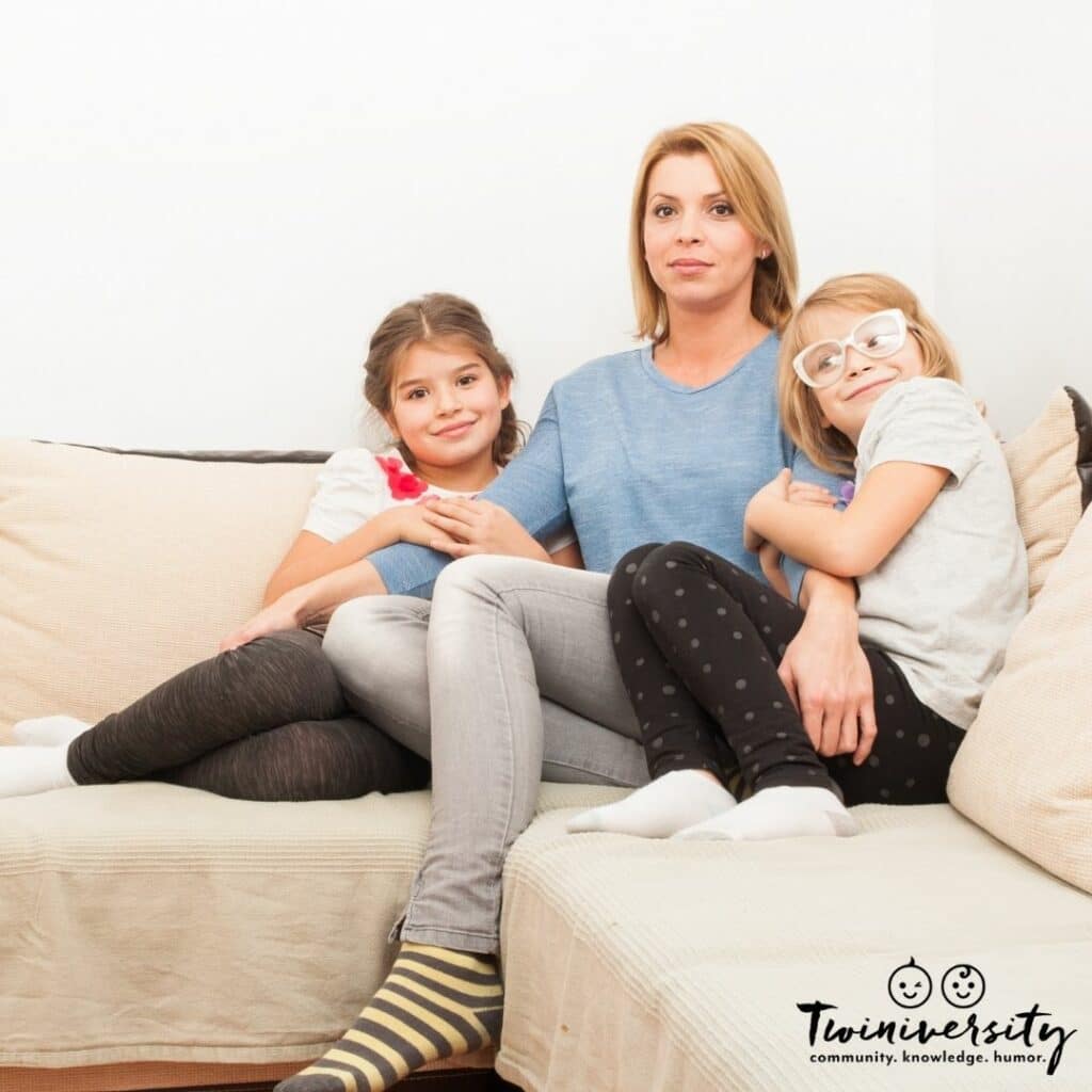 Single twin mom sitting on the couch with her twins. How does she do it solo?