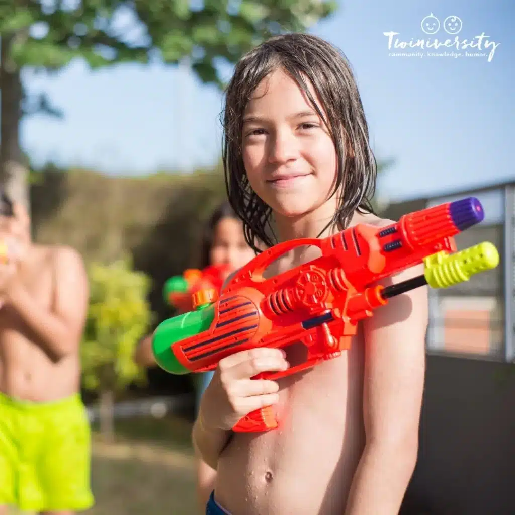 Boy holding a water gun, mid water gun fight.