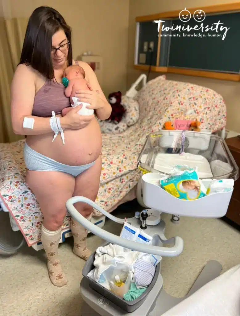 Postpartum mom holding one of her twins