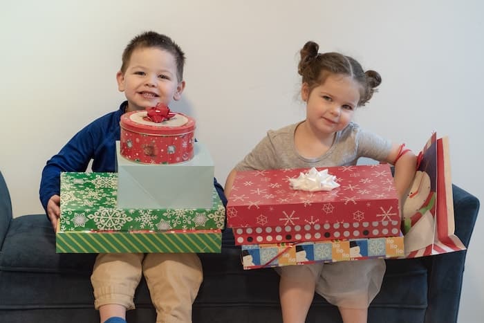 twin boy and girl holding a stack of gifts the 4 gift rule