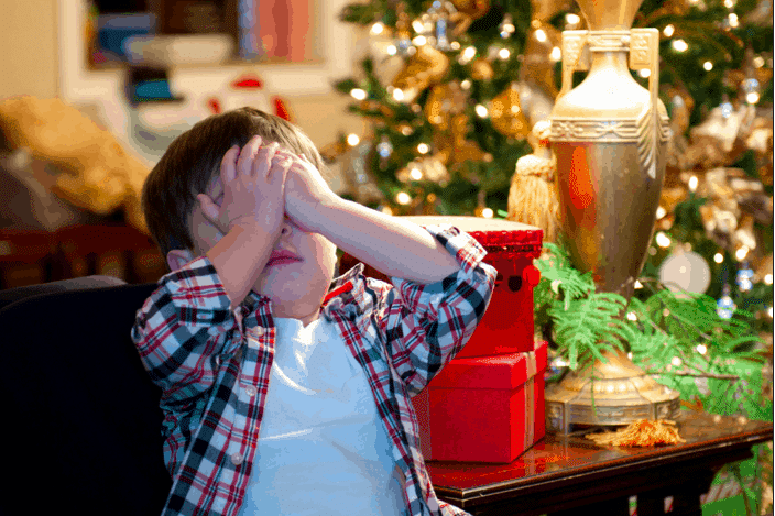 kids with hands over his eyes holiday stress