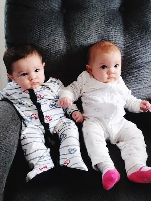 twin babies sitting on a couch maternity leave