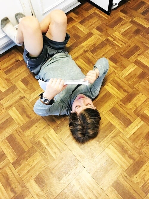 boy reading while laying on kitchen floor kids to read