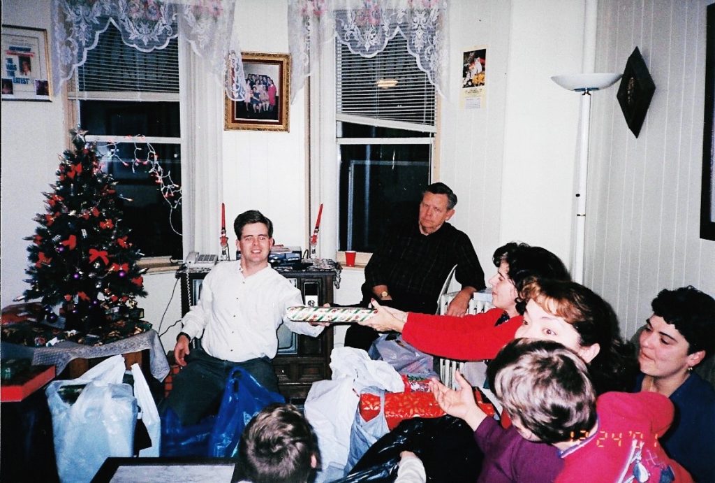 1980s photo of family passing gifts at christmas new traditions