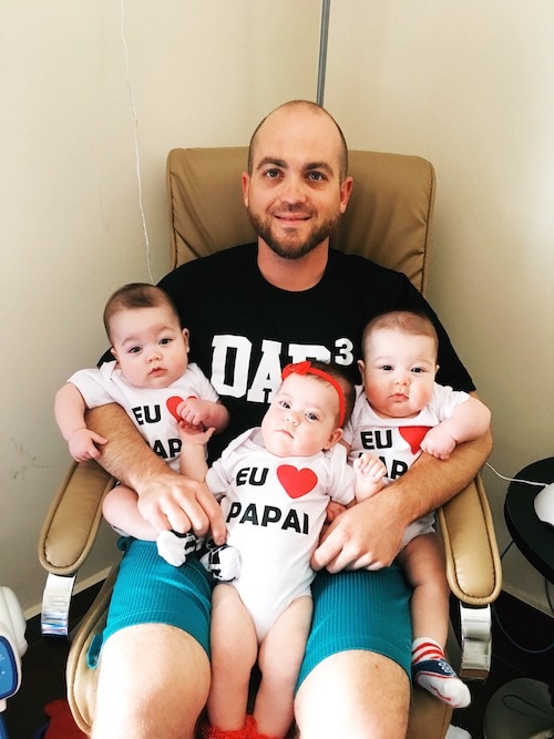 dad holding infant triplets