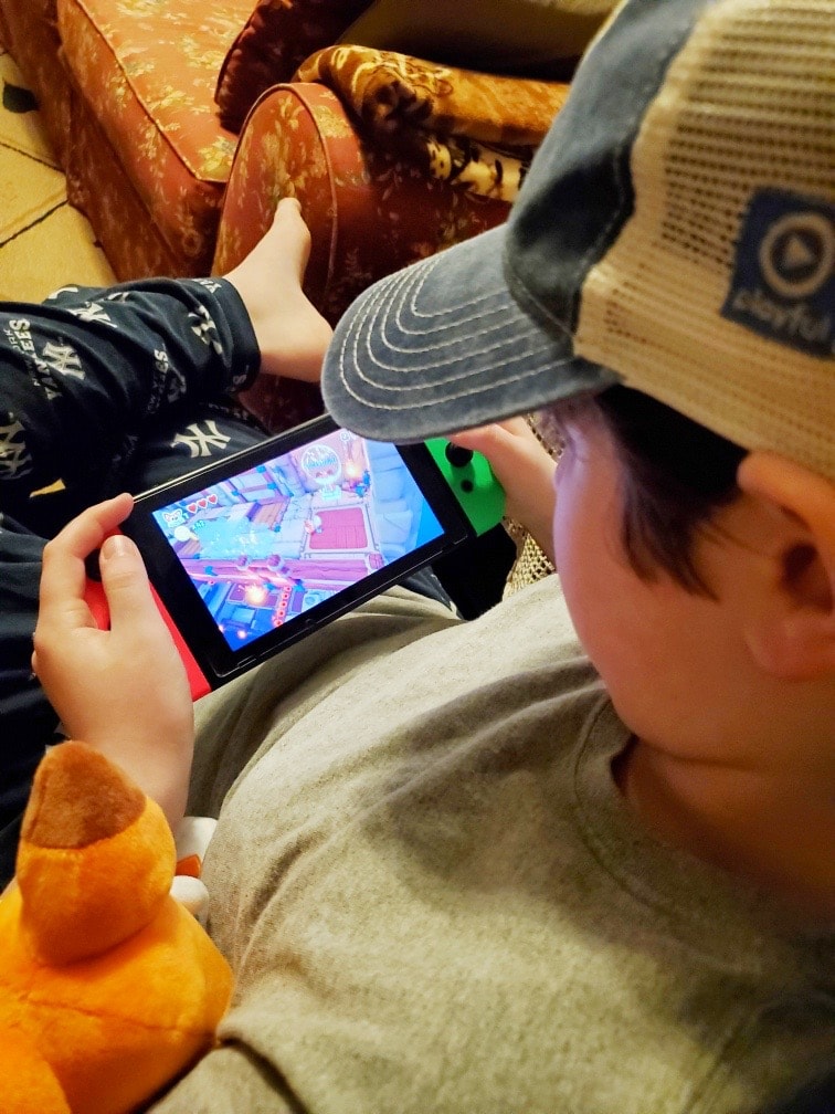boy with a hat sitting in a chair playing Super Lucky's Tale