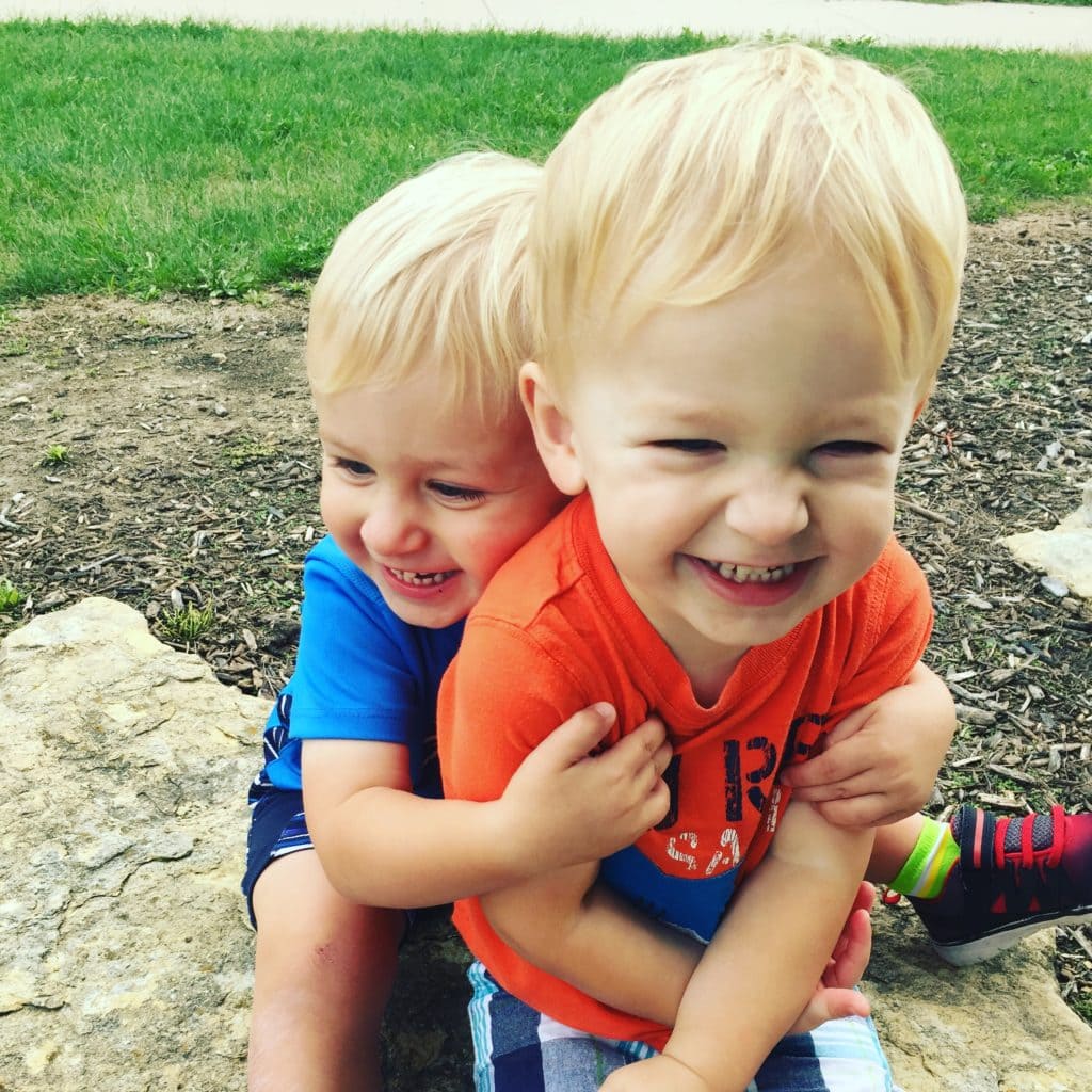 twin toddler boys hugging mother-in-law taught