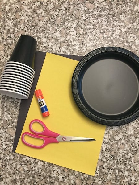 paper, scissors, black cups and plate