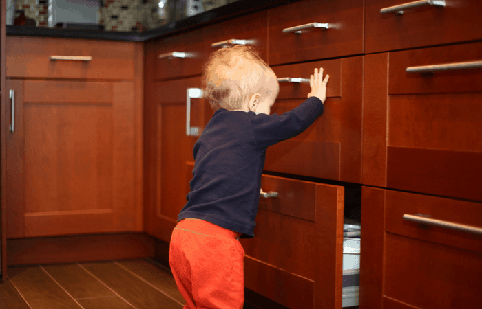 baby looking through kitchen drawers baby proofing