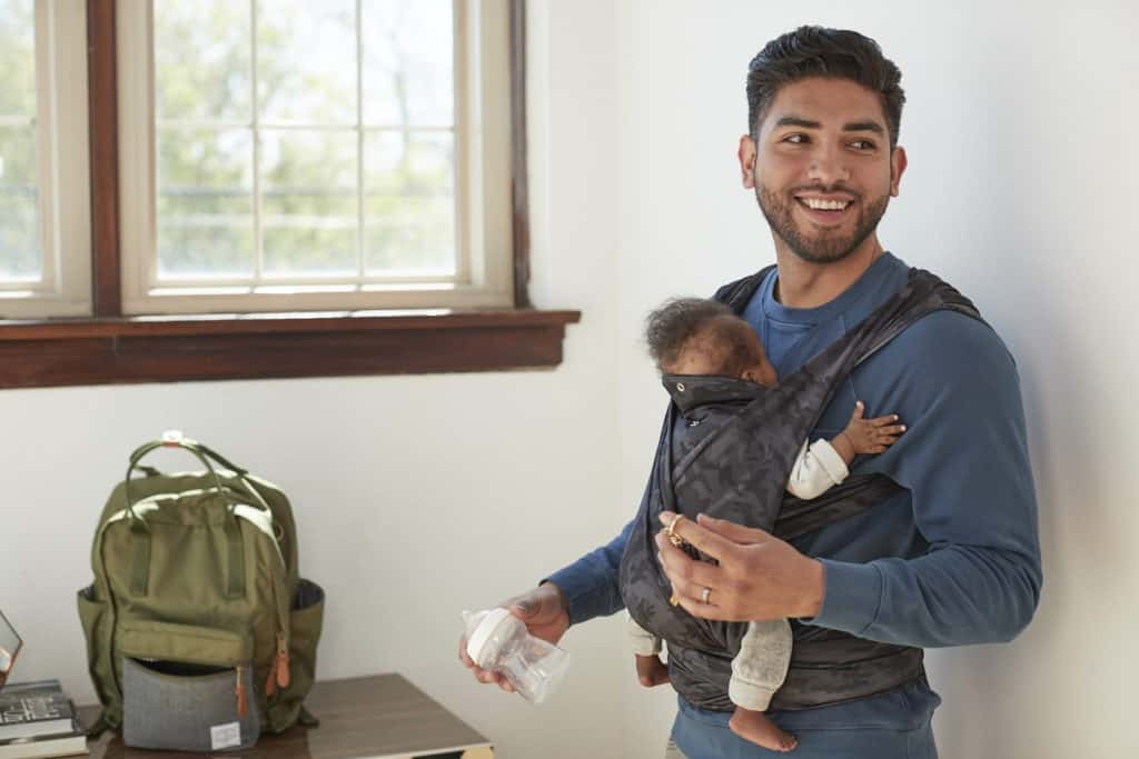 man wearing baby in baby carrier