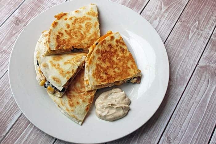 chipotle ranch chickne quesadilla on a plate with dipping sauce