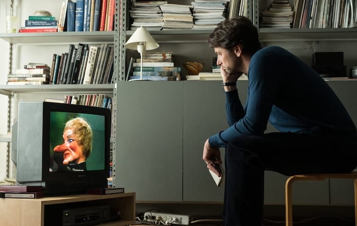 man watching TV screen a beautiful day in the neighborhood