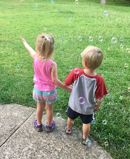 twin kids blowing bubbles mama of newborn twins