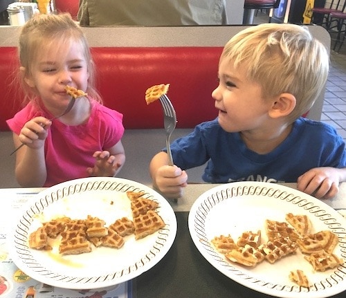 twin kids holding forks with waffles mama of newborn twins