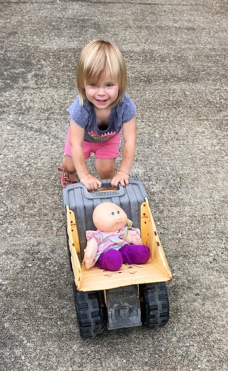 toddler girl pushing doll in a toy wagon Keep Twins Busy