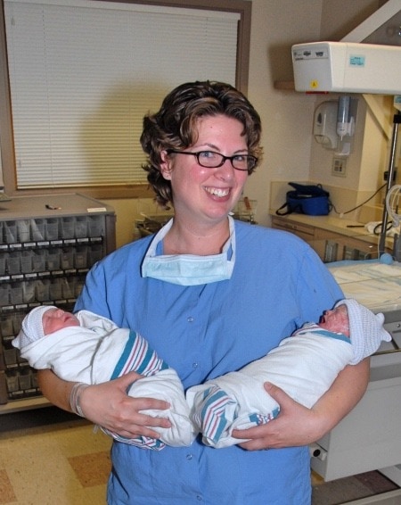 mom holding newborn twins reproductive assistance