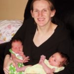 mom holding newborn twins exclusively breastfed twins