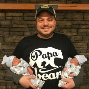 dad holding newborn twins stay-at-home parents of twins