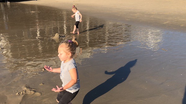 two girls playing at the beach evacuating