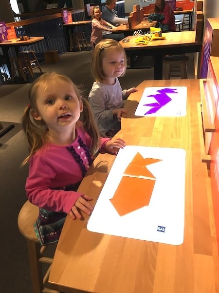 girls playing with tangrams love of math