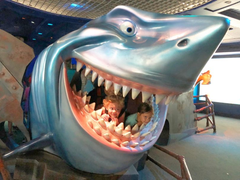girl twin toddlers in fake shark mouth disney world with twins