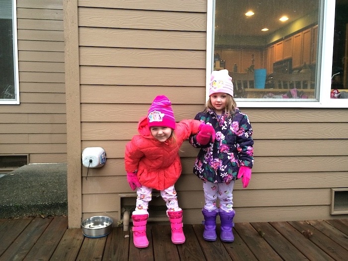 twin girls in coats outside three-year-old twins