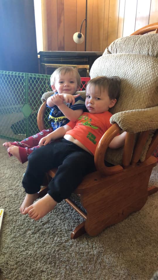 twin boys sitting in a chair why are you covered in poop 