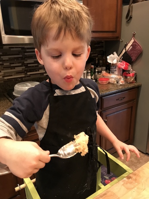 boy eating cookie dough on a spoon kids cooking
