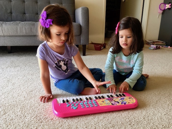 twin girls playing with a keyboard Sharing Between Twins