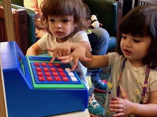 twin girls playing with cash register Sharing Between Twins