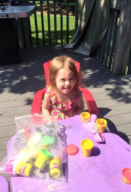 girl with play-doh preparing twins for kindergarten