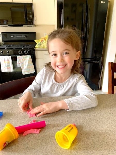 girl playing with play-doh preparing twins for kindergarten