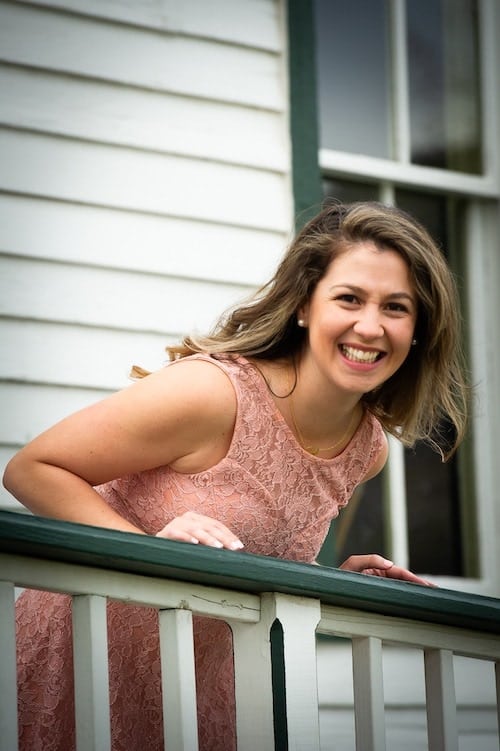 woman leaning over railing celebrate you
