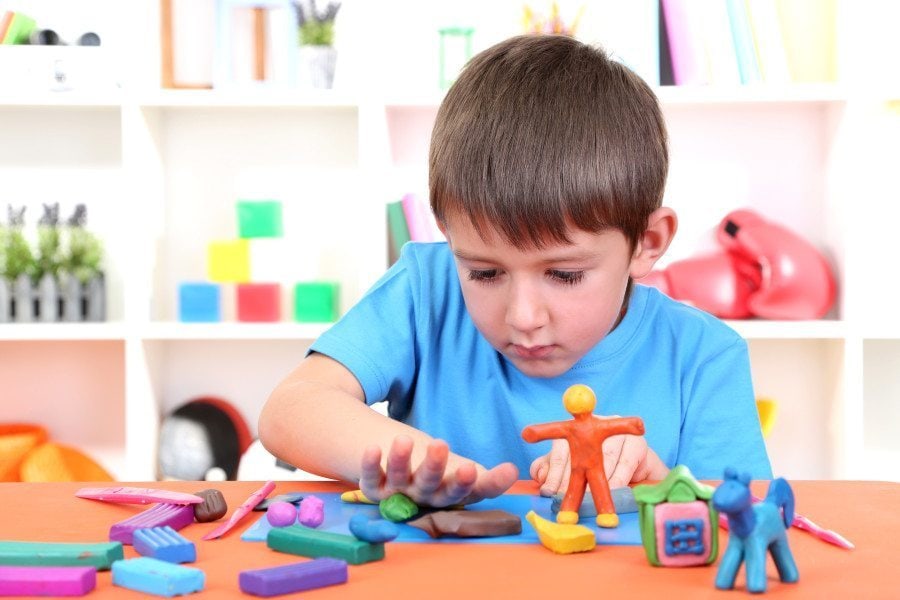 boy playing with toys at a table occupational therapy