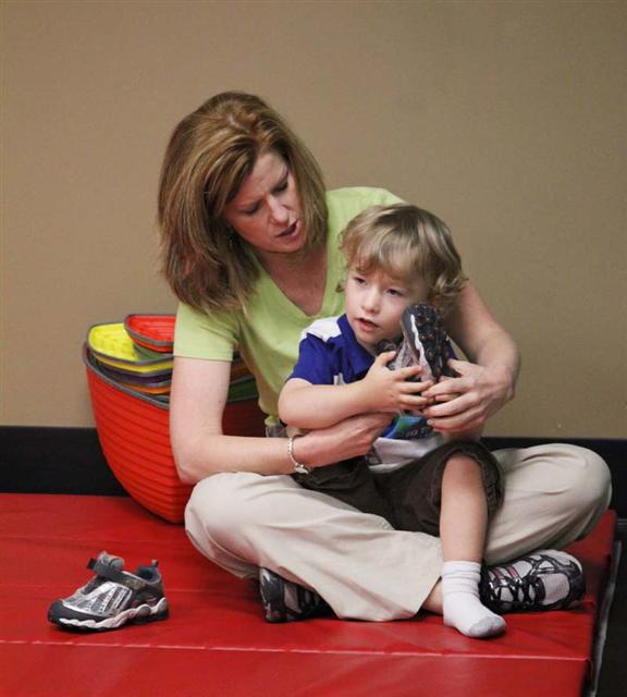 occupational therapist with child on a mat 