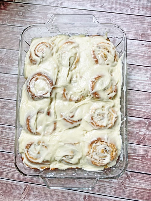 cinnamon rolls with cream cheese frosting in a pan