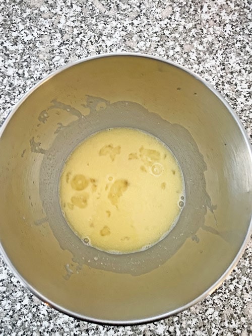 egg mixture in a mixing bowl cinnamon rolls