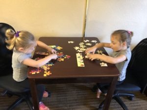 two girls playing a puzzle in a hotel evacuating